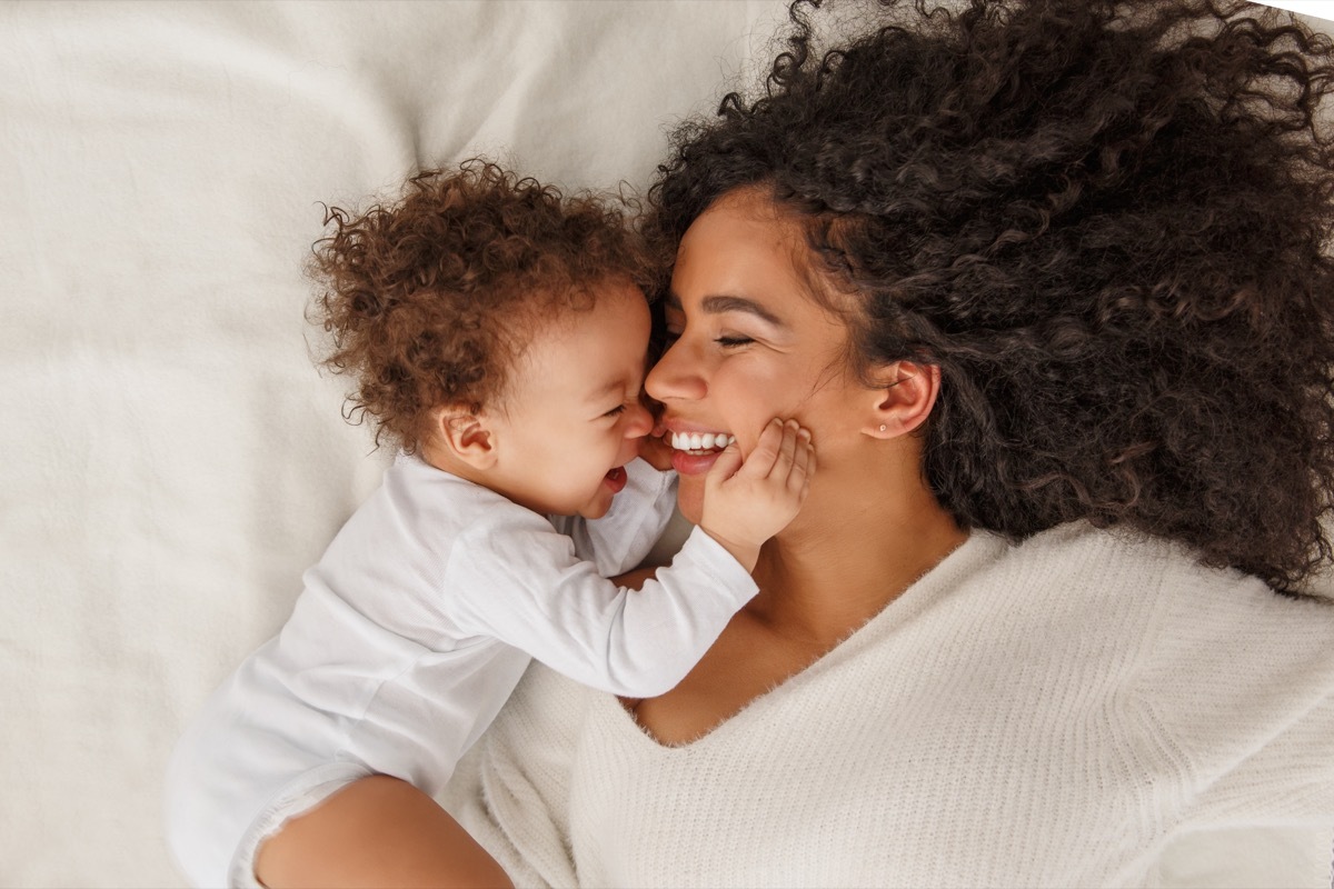 mother smiling at baby in bed