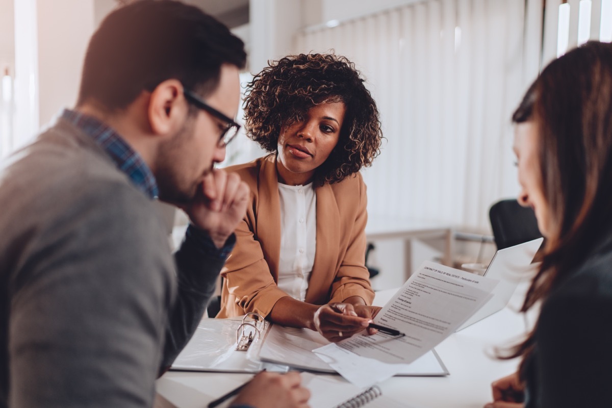 Man and woman having meeting with female financial advisor