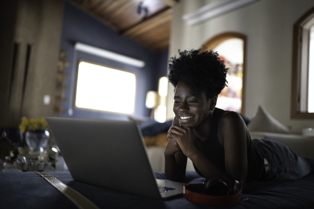 Young women watching movie on a laptop at home