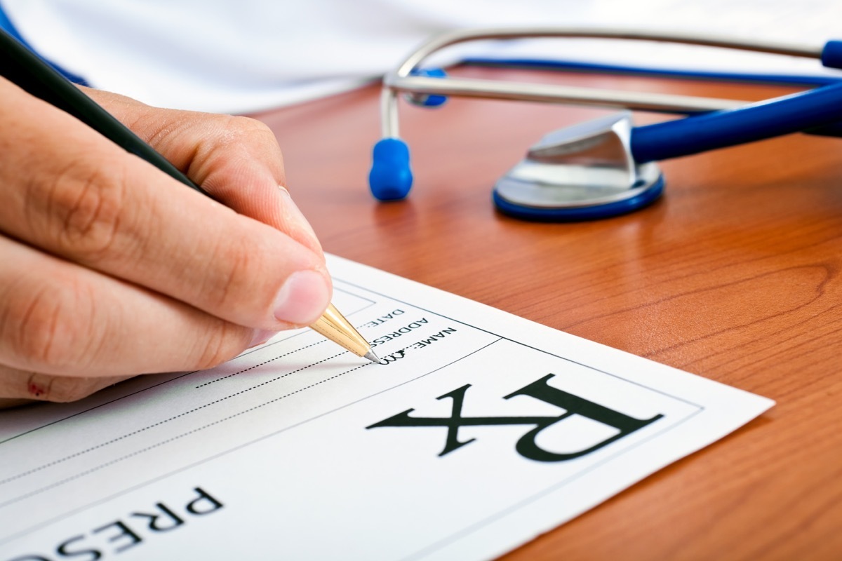 Closeup of doctor's hand writing prescription