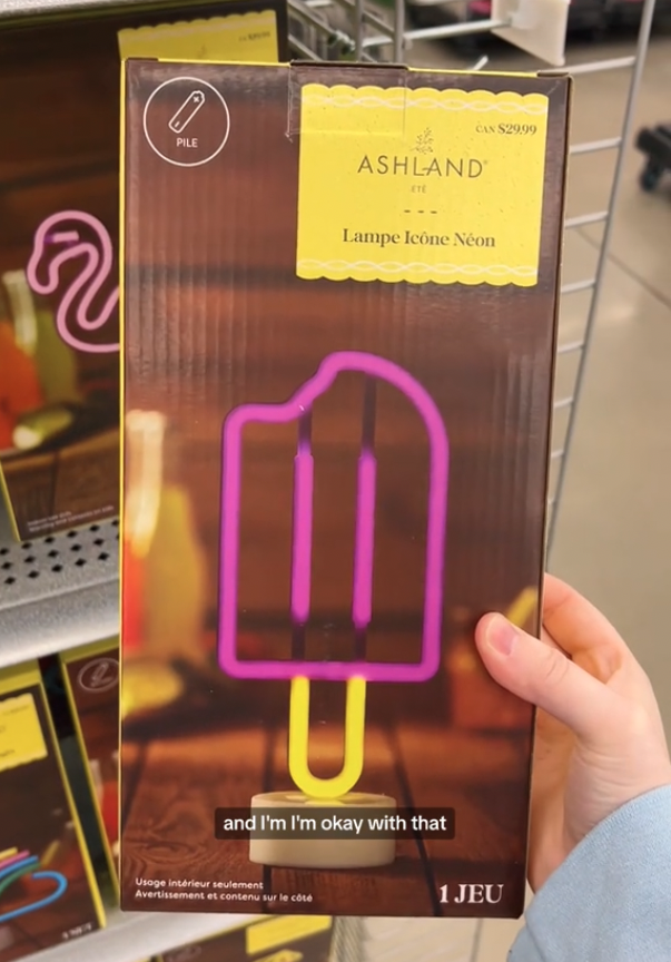 shopper holding up neon popsicle light at Michaels