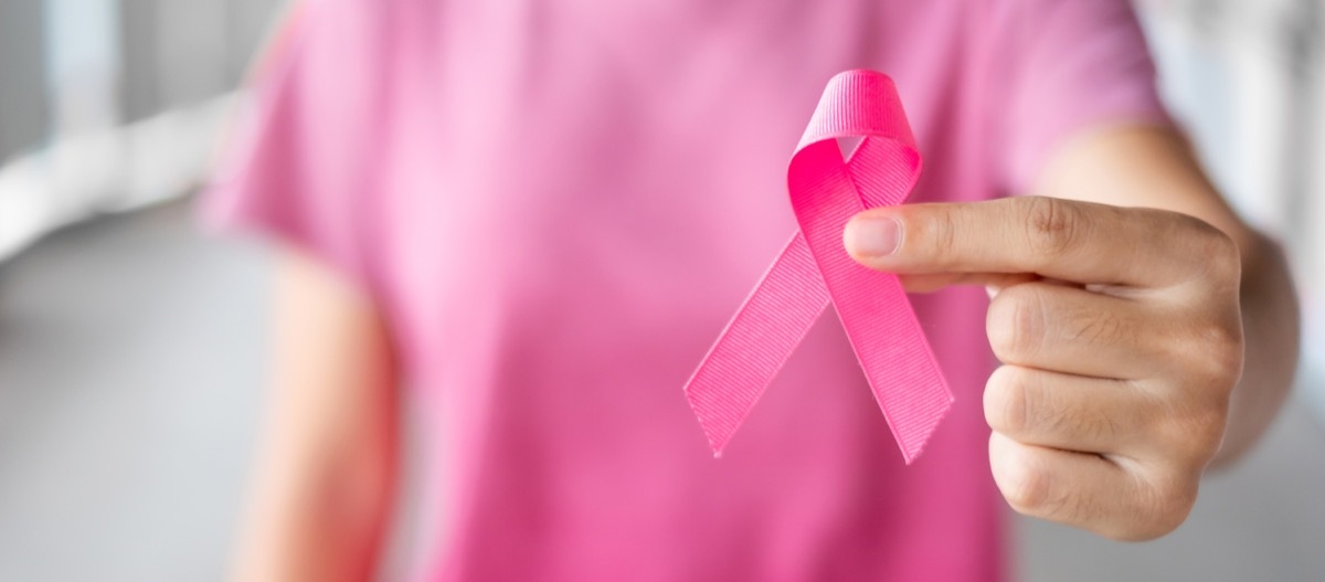 Hand Holding up a Pink Breast Cancer Ribbon