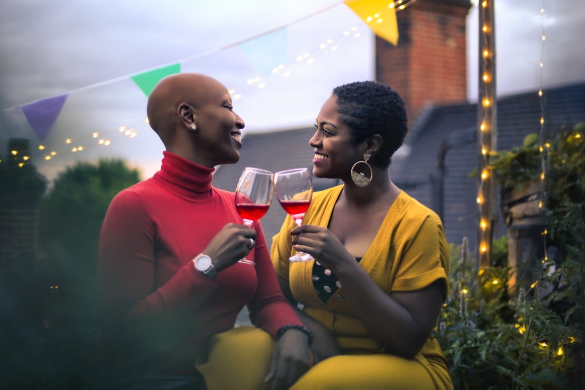 two women enjoying a drink together on top of a rooftop