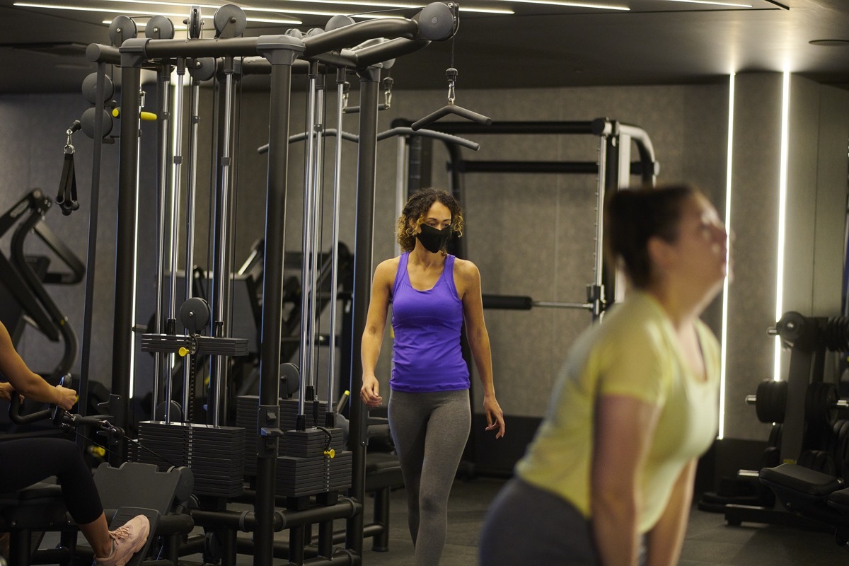 smart young woman wearing facemark as she travels around the gym