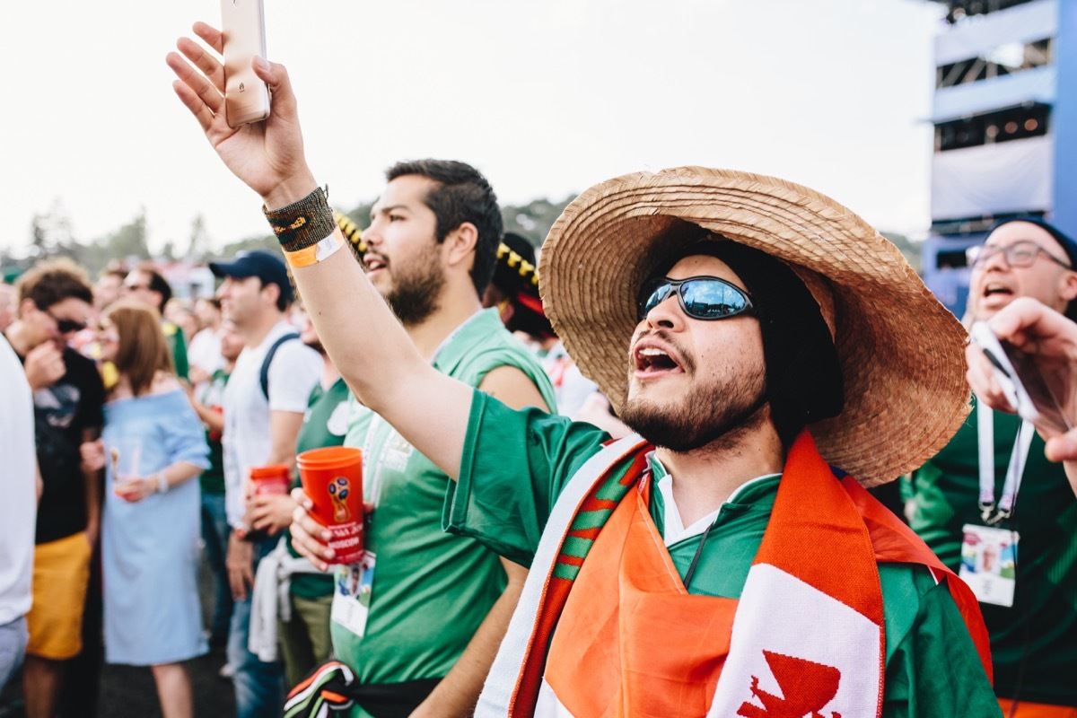 Mexican fans in uniform sing the national anthem during the World Cup