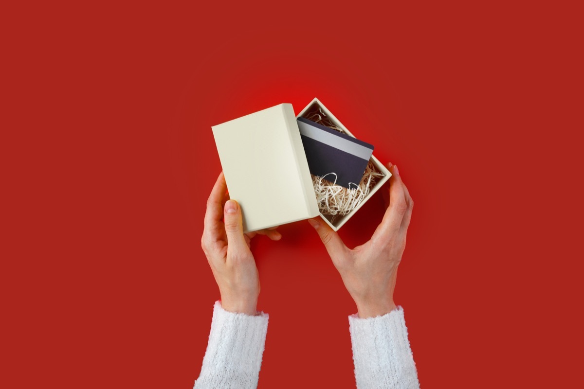 Woman opening a gift box with a card inside