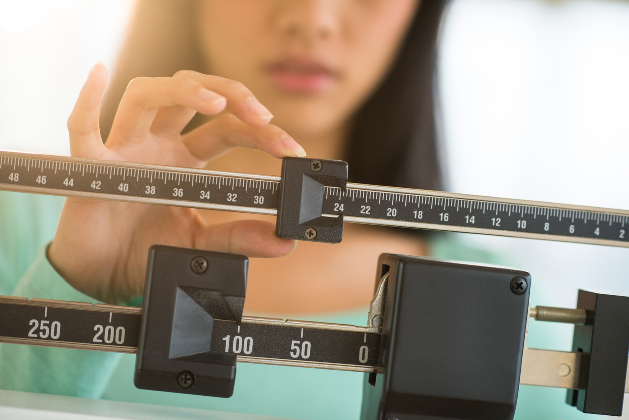 Woman adjusting balance weight scale