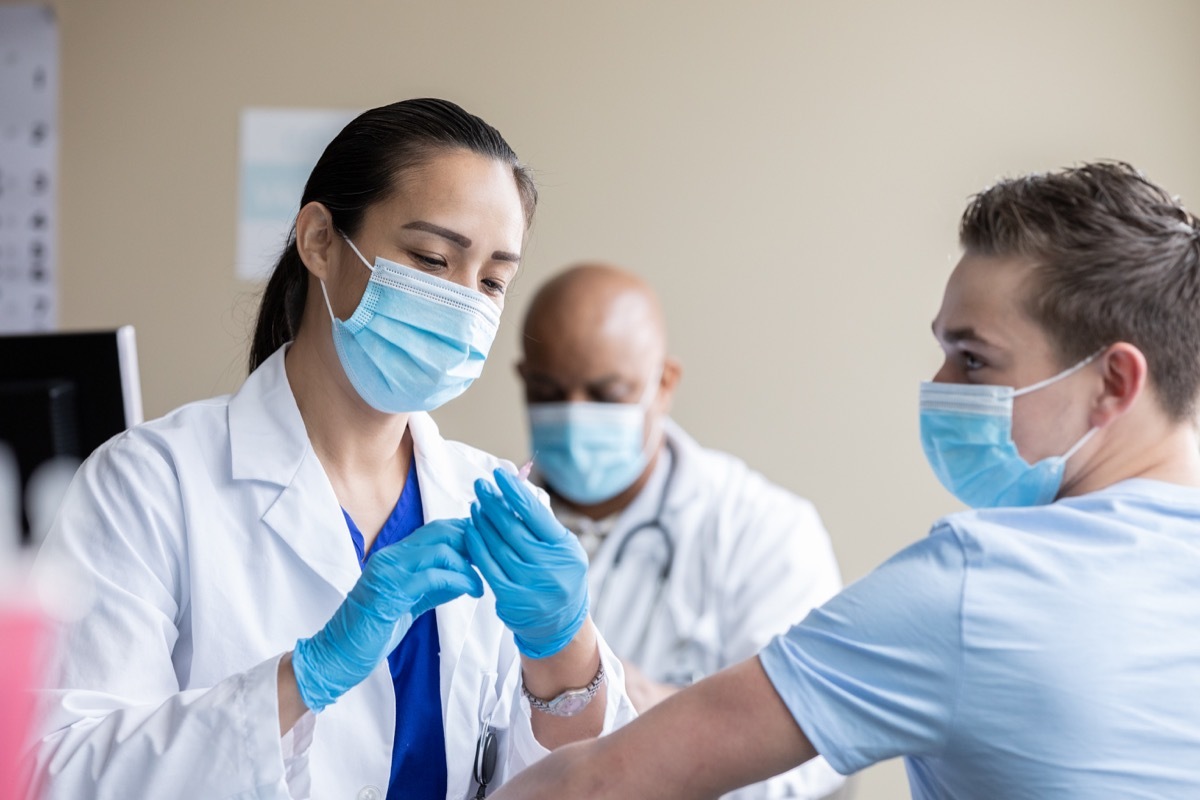 Mature healthcare worker is giving COVID-19 vaccines to patients