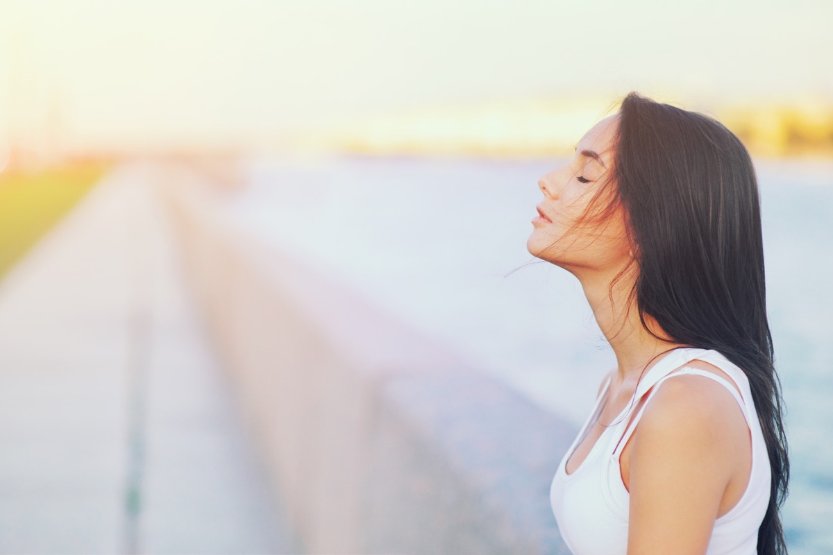 young woman smelling summer air