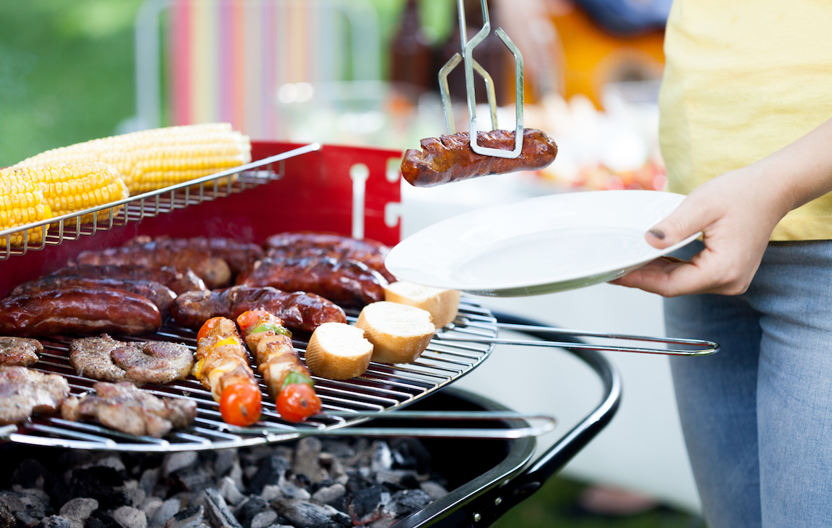 Closeup of woman dishing out grilled sausage