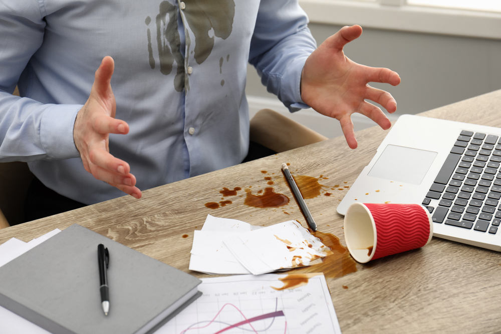 man spilling coffee on himself