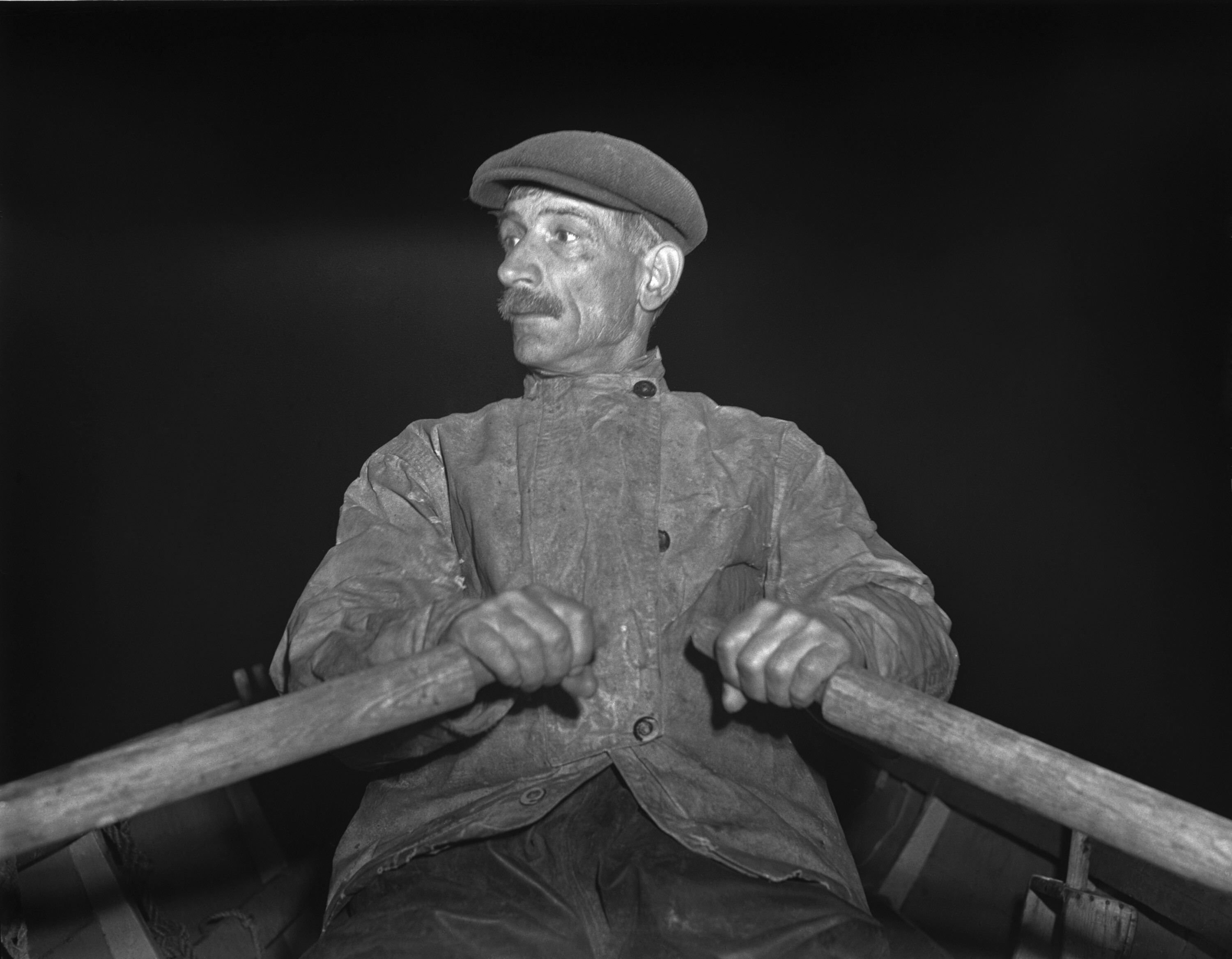 Fisherman rowing out to his boat early in the morning for the fishing banks off Cape Cod in 1942