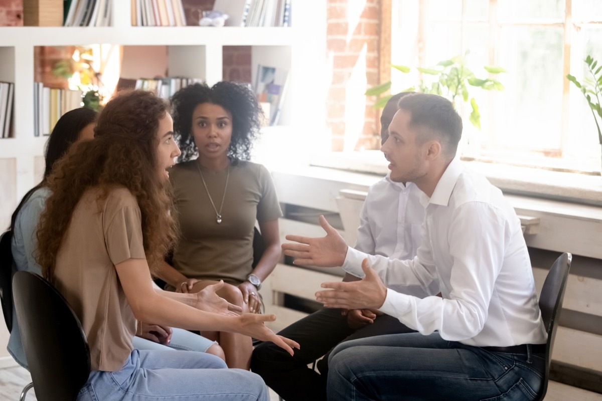 group apologizing and arguing with woman overlooking