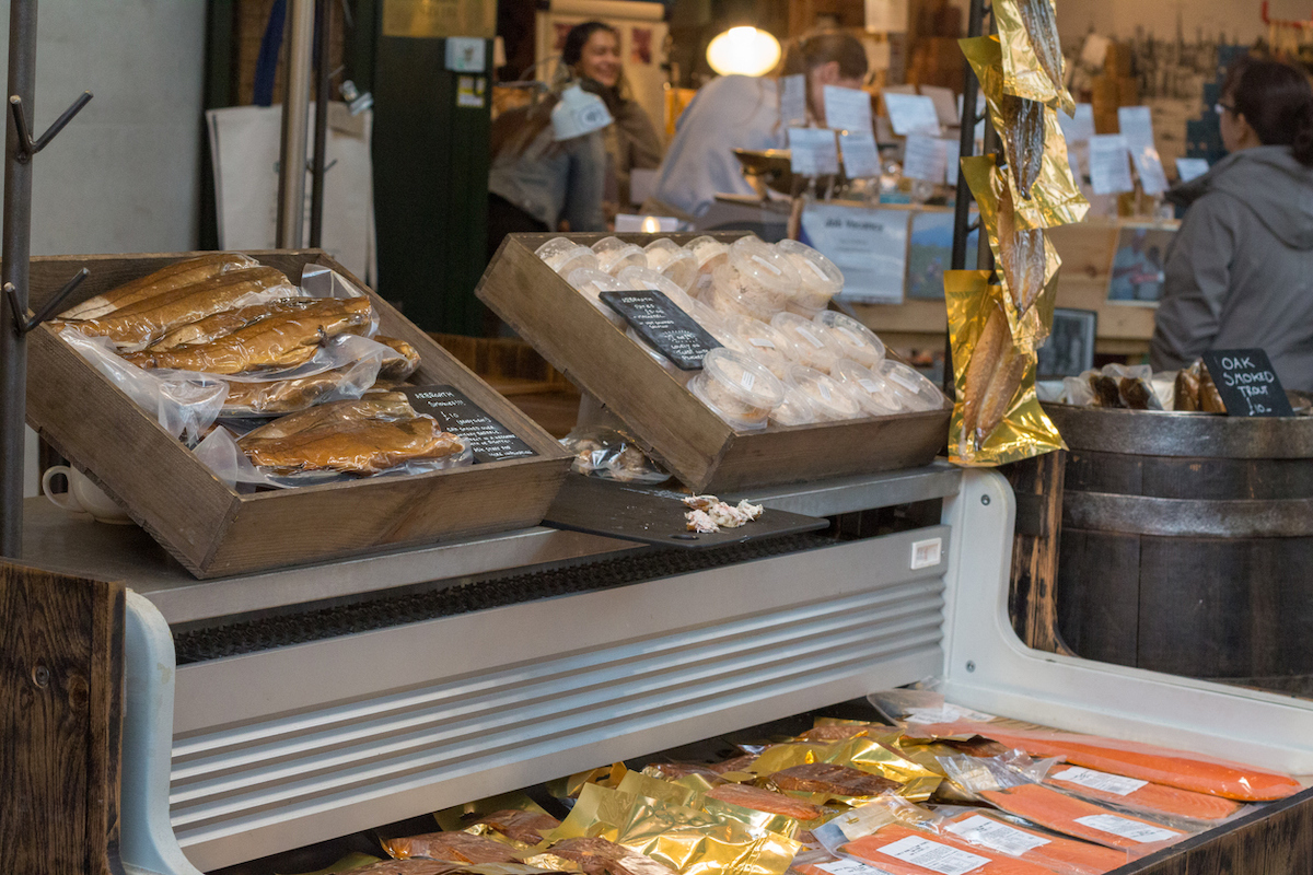 A market stall selling smoked fish in Borough Market, London, with people in the background