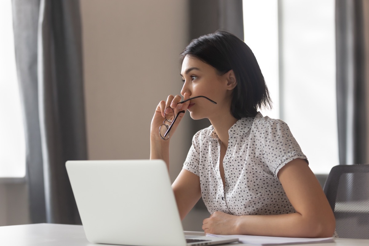 Anxious woman in a white collared shirt in her office. 