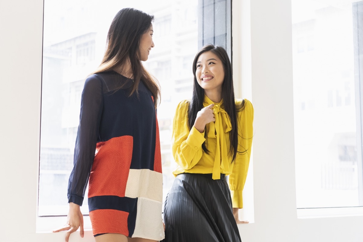 Mid adult woman talking to friend, smartly dressed, fashionable clothes, stylish, modern clothing