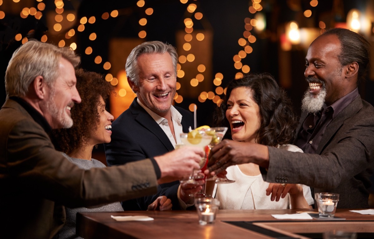 Group Of Middle Aged Friends Celebrating In Bar Together