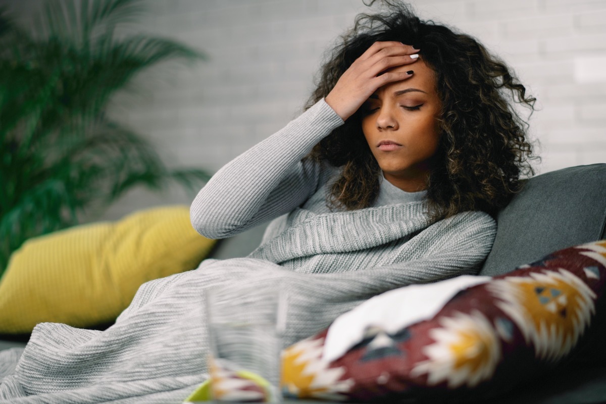 woman lying on sofa having fever