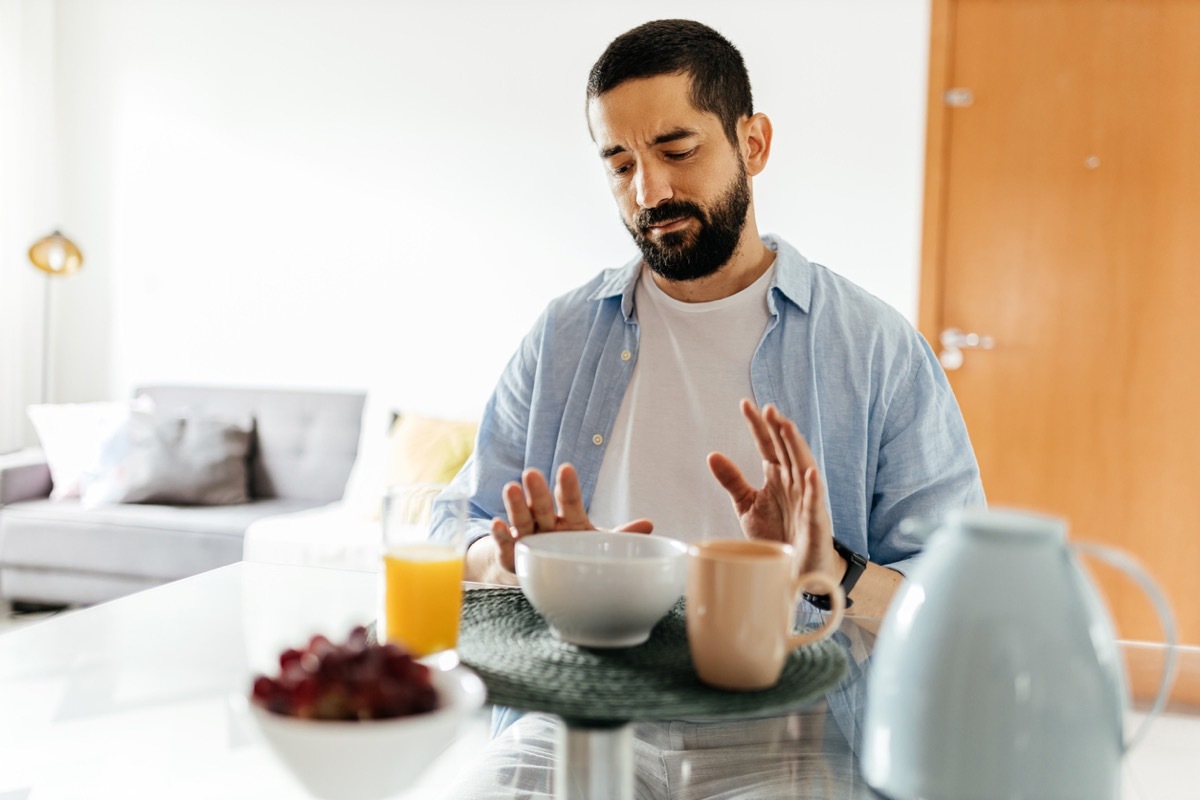 Depressed man at the table suffering from lack of appetite