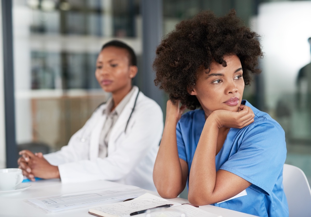 Shot of a young doctor looking bored while sitting in on a meeting at a hospital