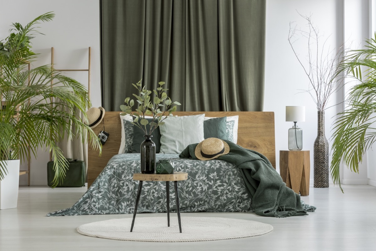 bedroom with closed curtains behind bed