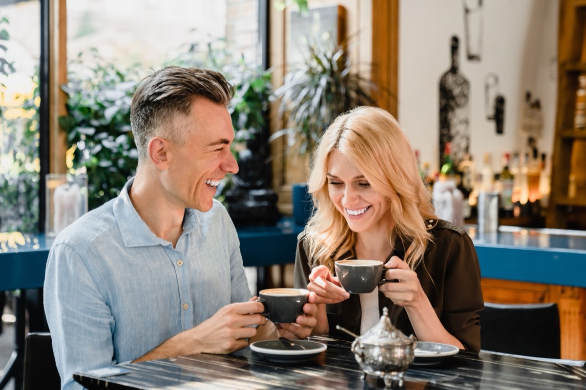 Happy cheerful caucasian middle-aged couple spouses drinking coffee talking enjoying romantic date together in cafe restaurant bar