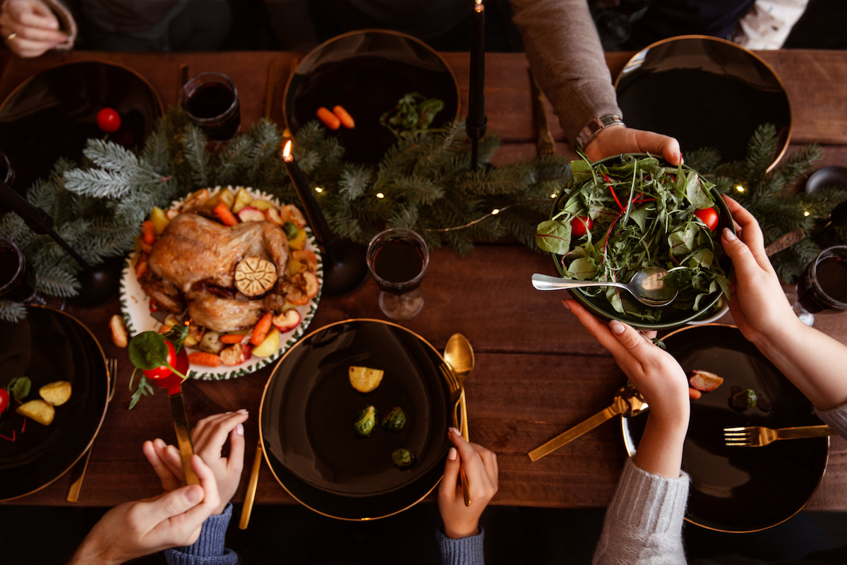 people pacing plates as they share Christmas dinner together.