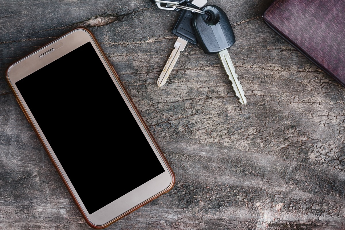 phone wallet and keys laying on a wooden table