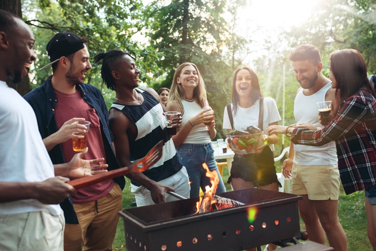 young friends grilling outdoors