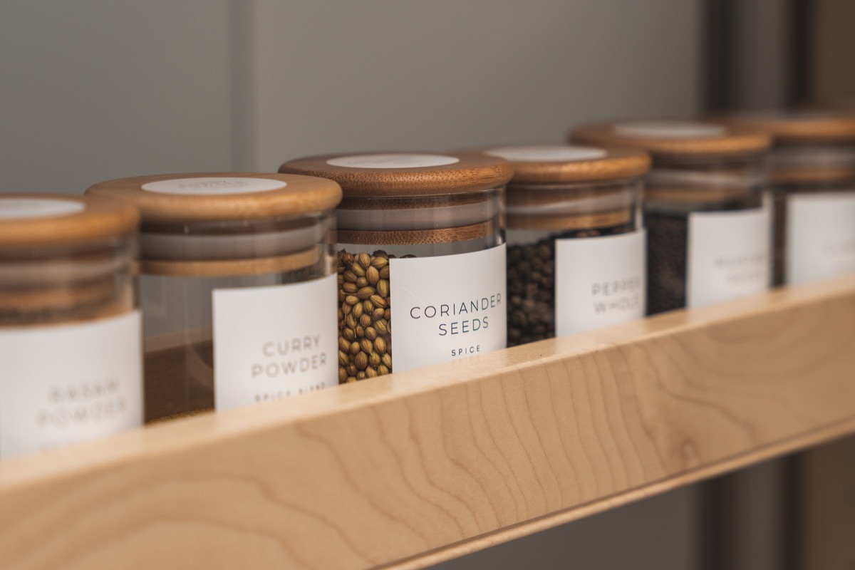 Organized, labeled food pantry in kitchen with spices, grains, flours, and rice