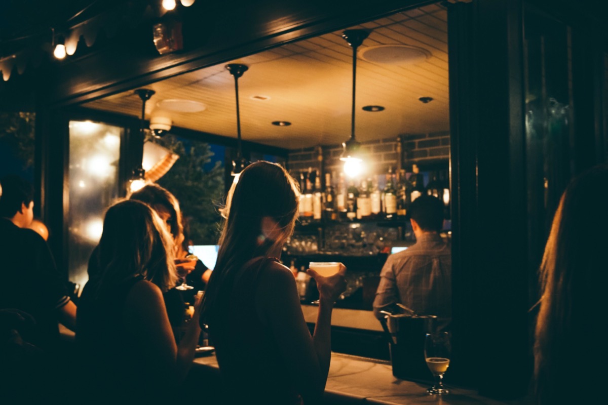 A woman ordering drinks in bar.