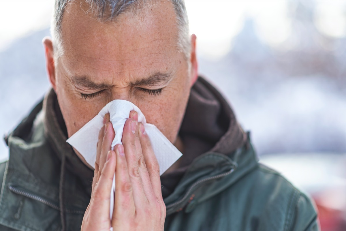 Man blowing his nose in the cold weather