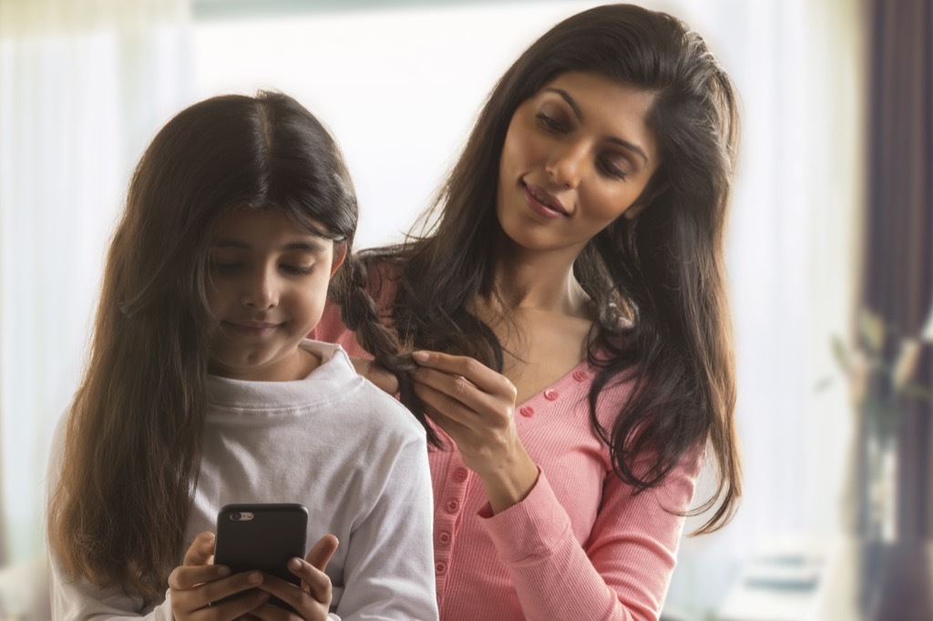 mother combing daughter hair