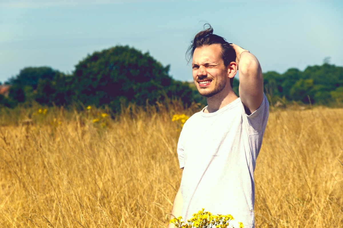 Young man squinting at the sun