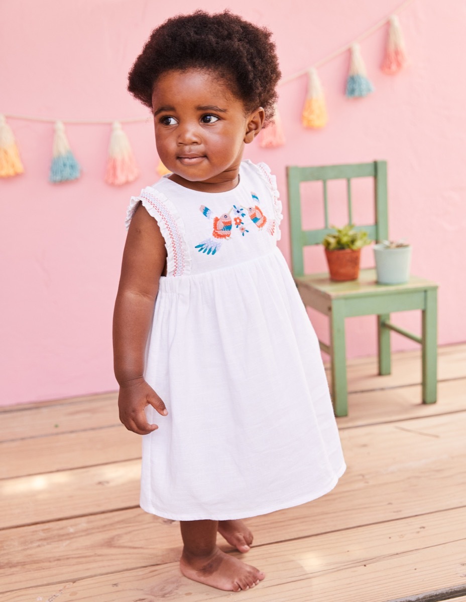 girl wearing embroidered white dress, end of summer sales 2019