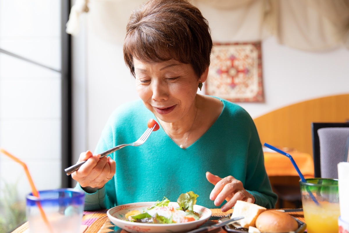 woman eating healthy food with tomatoes in salad