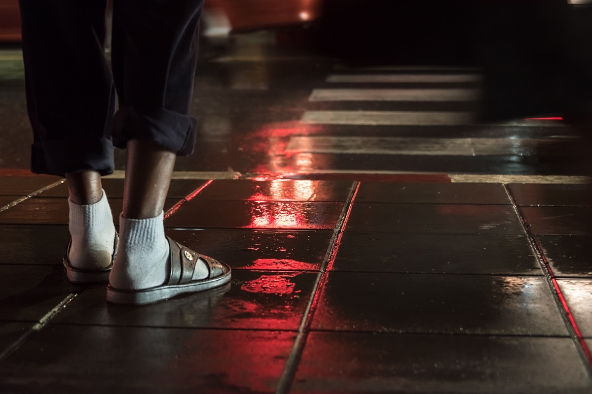 man wearing socks and sandals at night