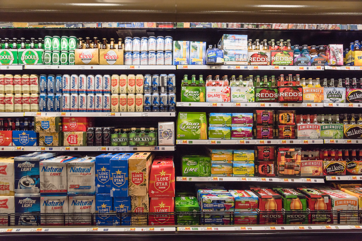 Various bottles of craft, microbrews, IPAs, bitter, ale, wheat, domestic and imported beer styles from around the world on shelf display in store.