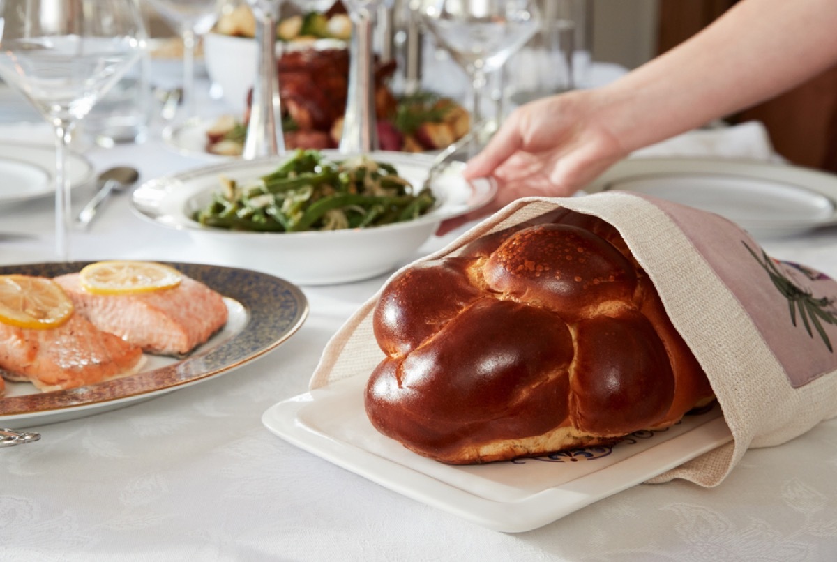 woman placing challah and vegetables on seder table, rosh hashanah facts