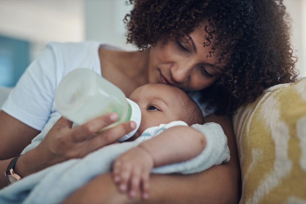 Shot of a baby girl being bottle fed by her mother on the sofa at home