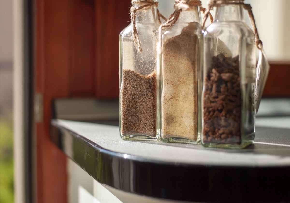 collection of botlles with seasonings on a table, indoor daylight shot