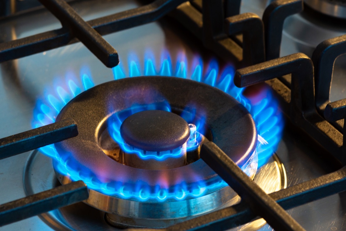 Gas burning with blue flames on the burner of a gas stove. Concept of carbon footprint and price of natural gas on the market