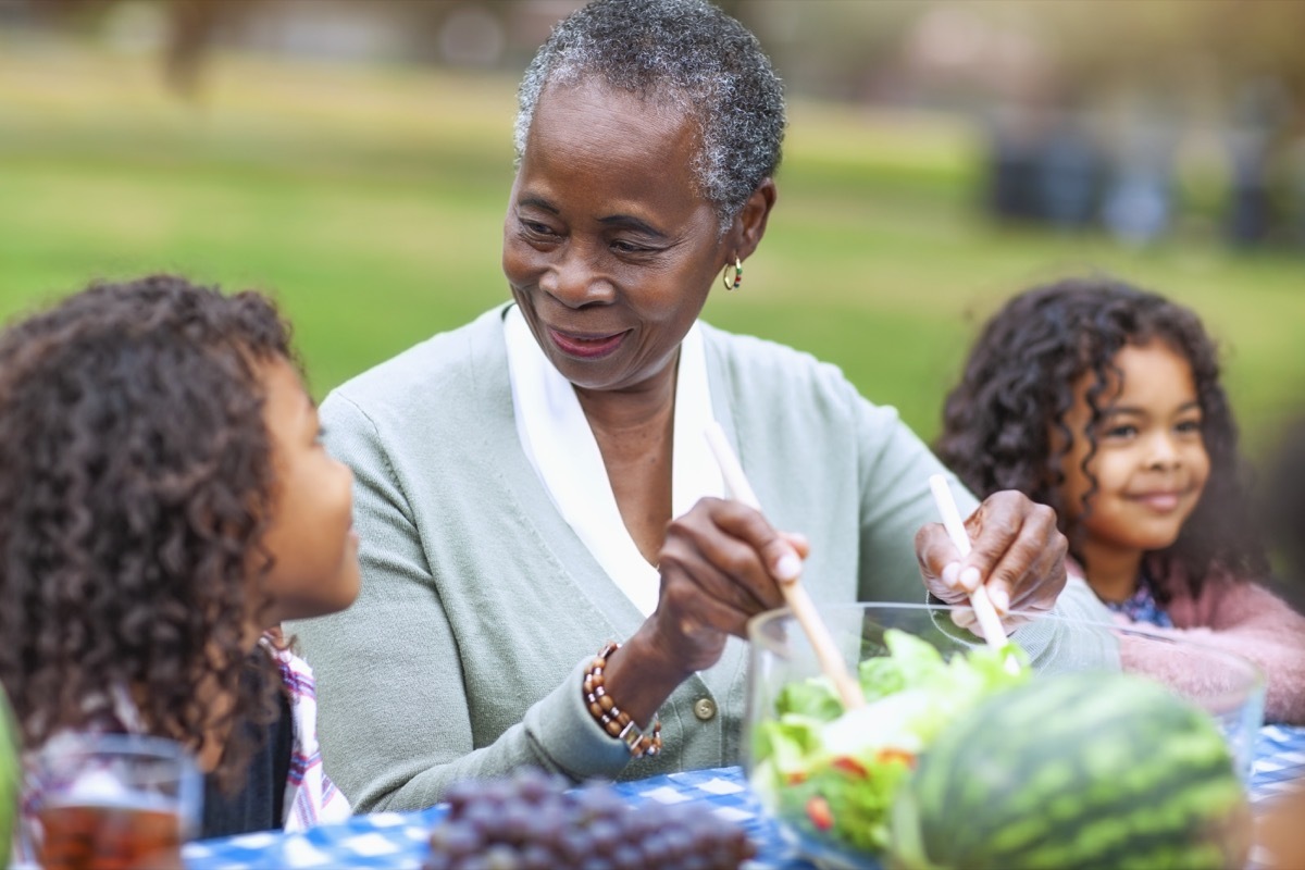 Grandmother with two granddaughters at picnic in park