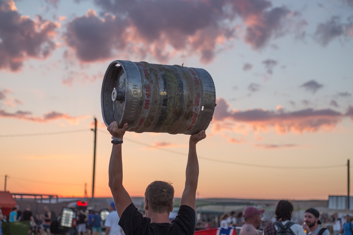 Man holding keg of beer tailgate party