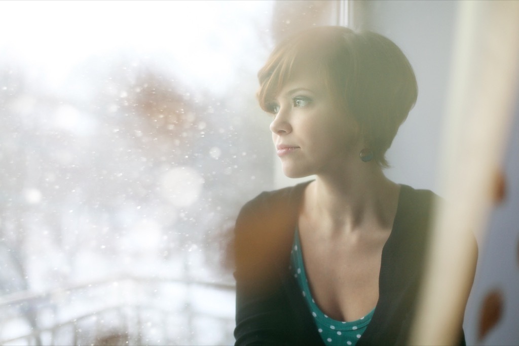 stressed out woman sitting by window stress