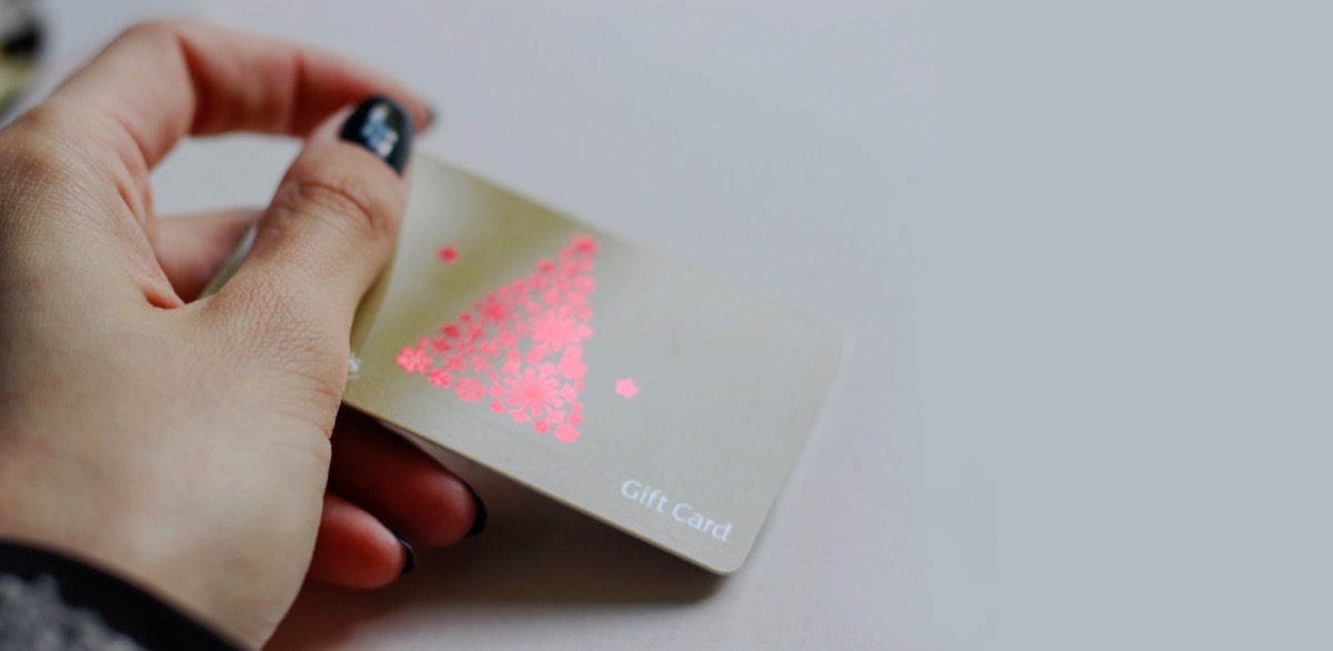 Woman's holding Sainsbury's Gift Card, wine illustration, red christmas tree