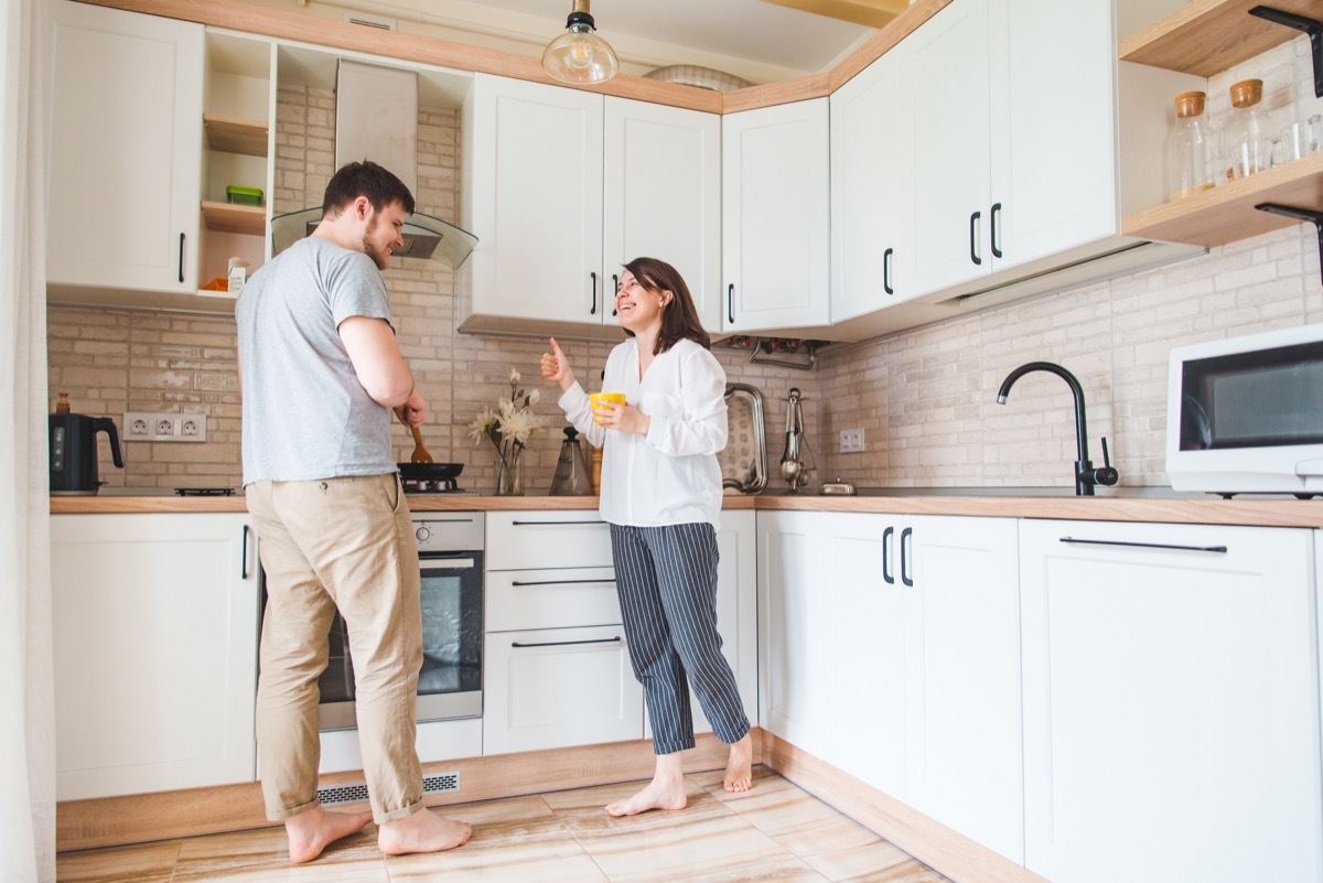 couple talking at the kitchen. man cooking breakfast. young family spending time together