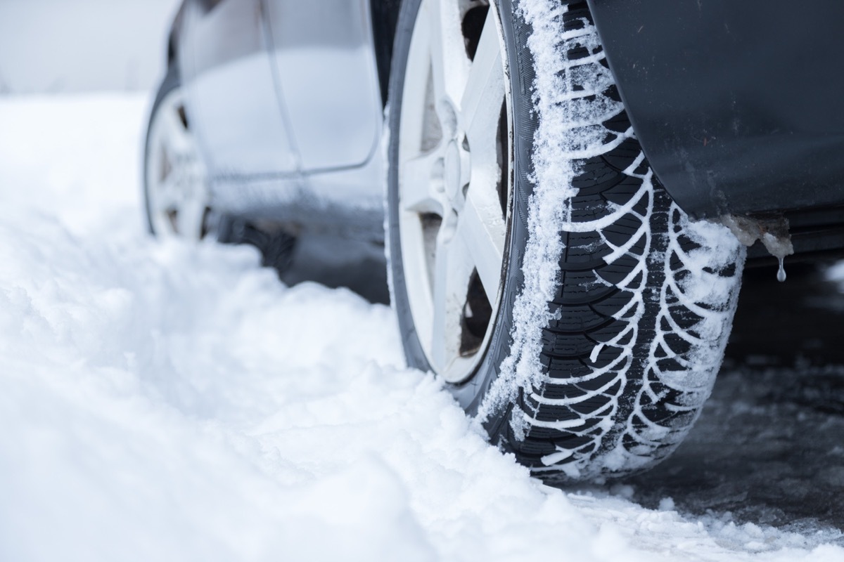 Close up of car tire covered with snow on a slippery road