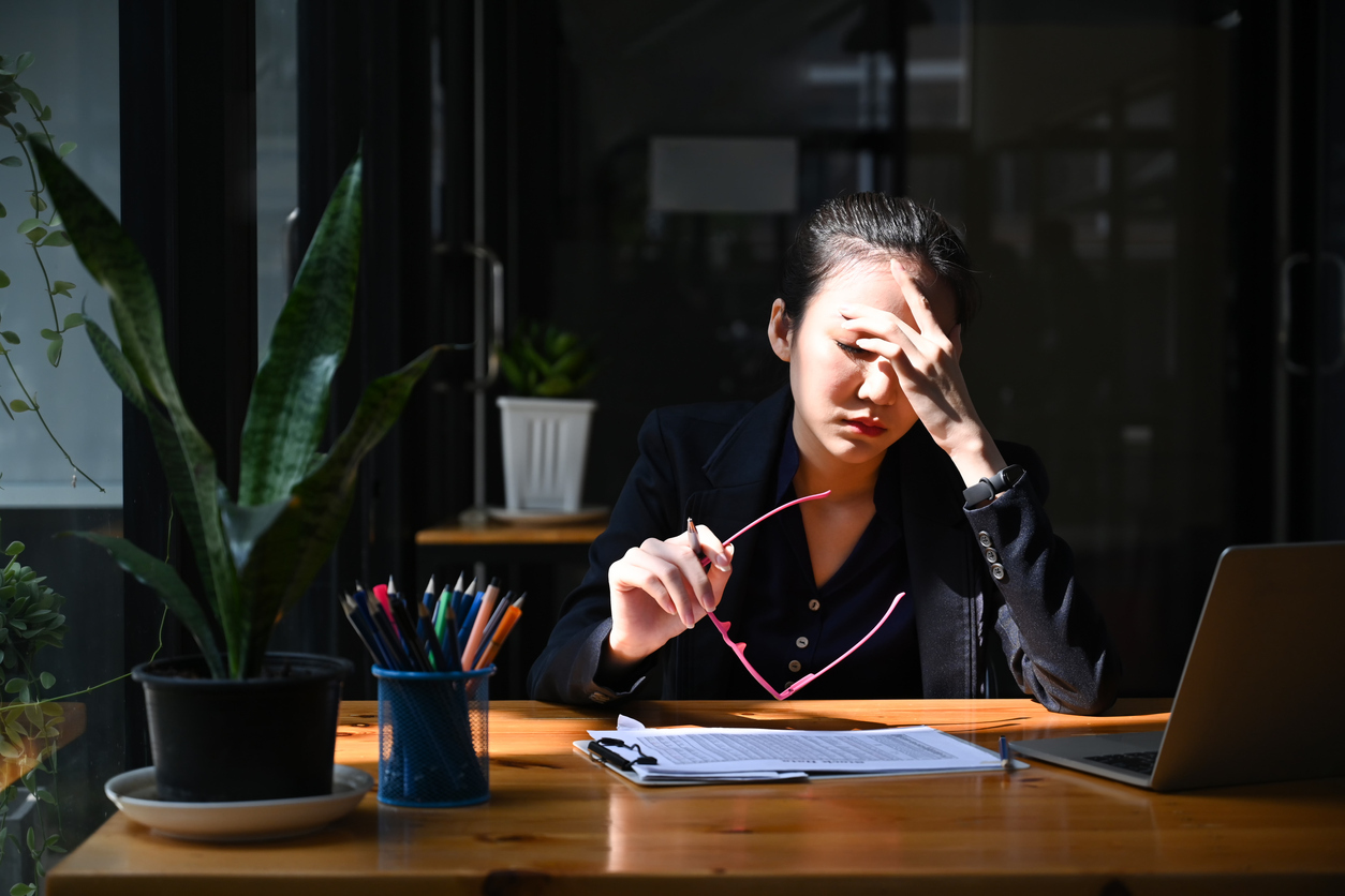 Overworked businesswoman take off glasses and massaging her head.