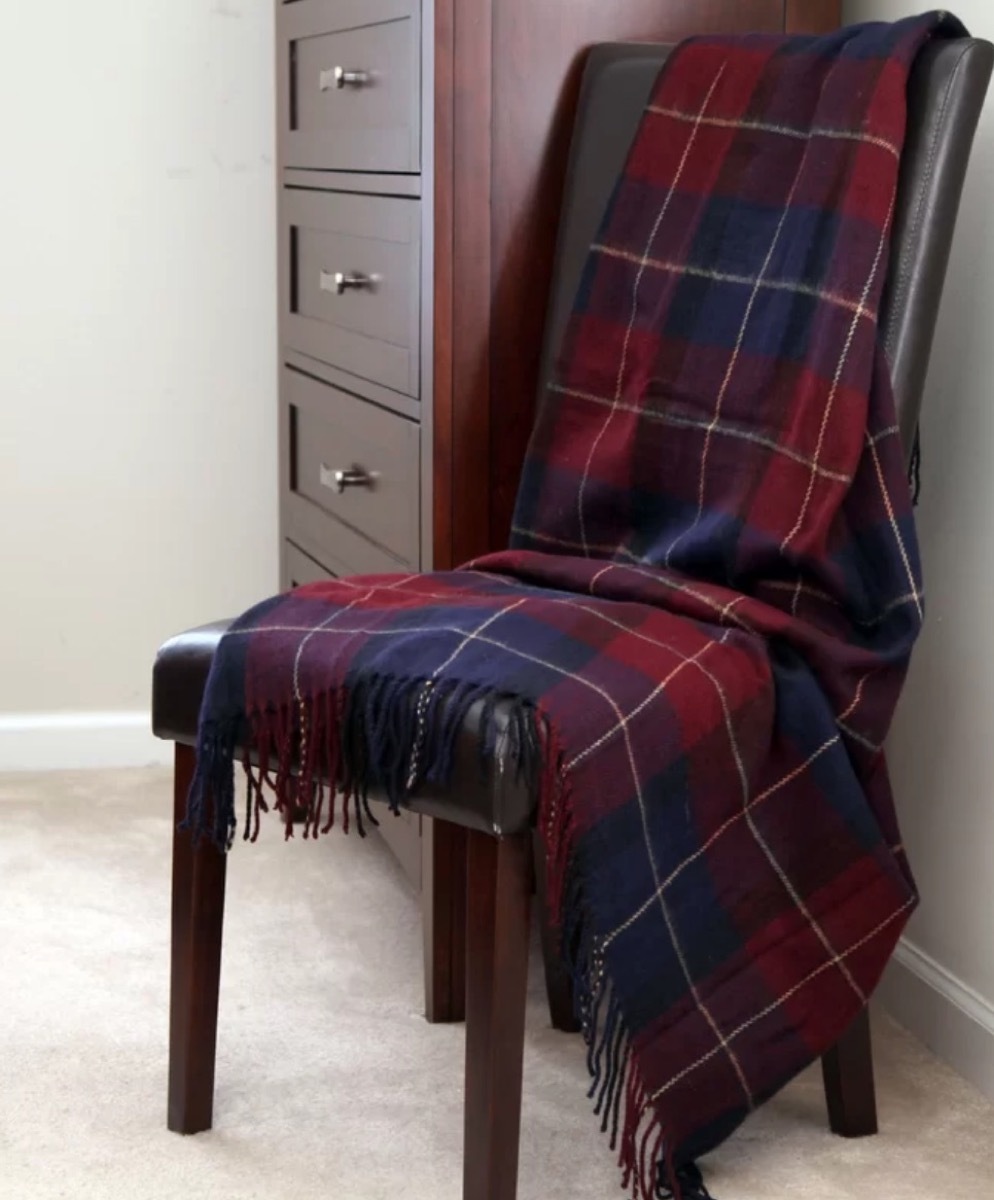 red and blue plaid blanket draped over a leather chair